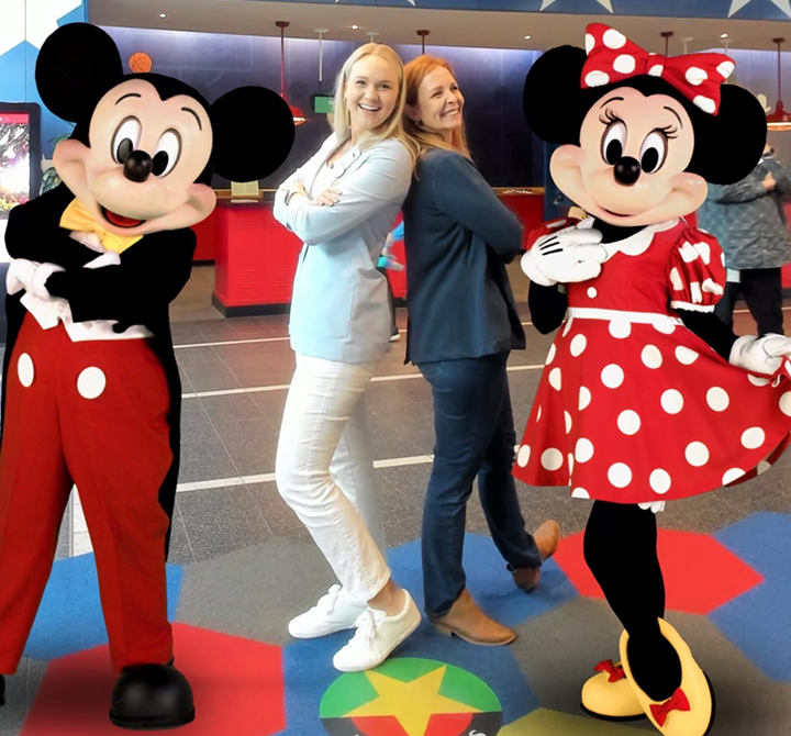 Mickey and Minnie posing with two executive women