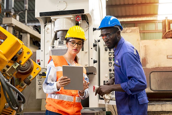 Man and woman holding tablet in a manufacturing plant